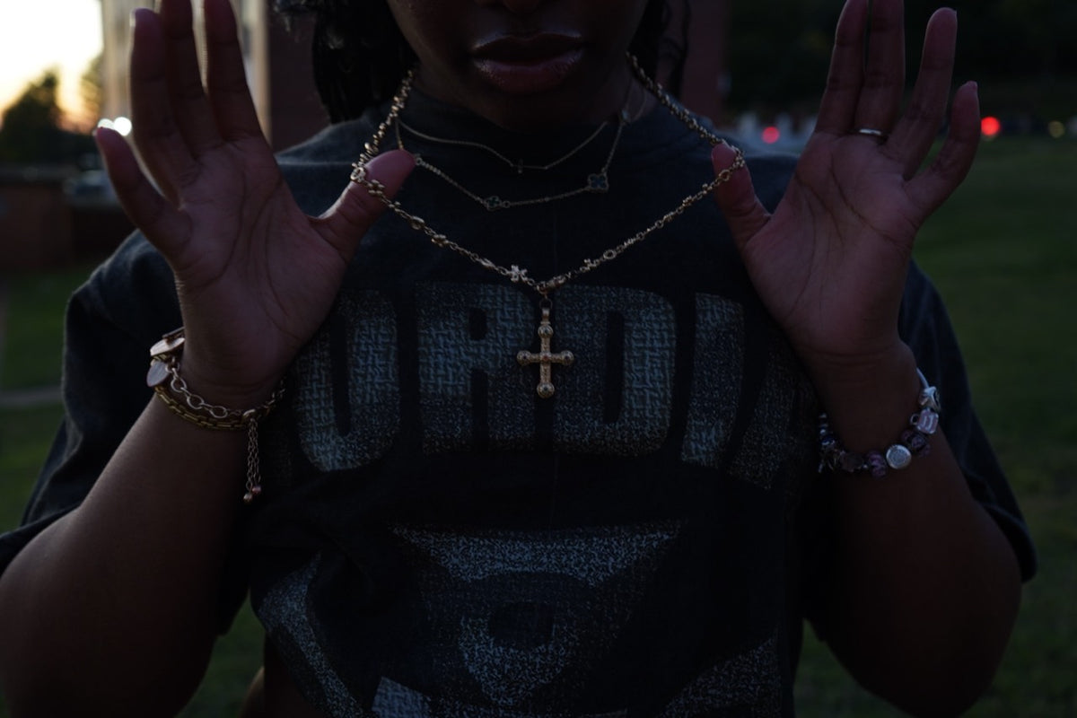 Close-up of a charcoal Cordial graphic tee and jewelry